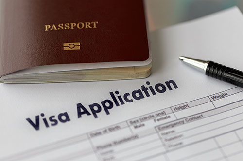 Passport and K-1 visa application form with pen representing the K-1 fiancé visa application process