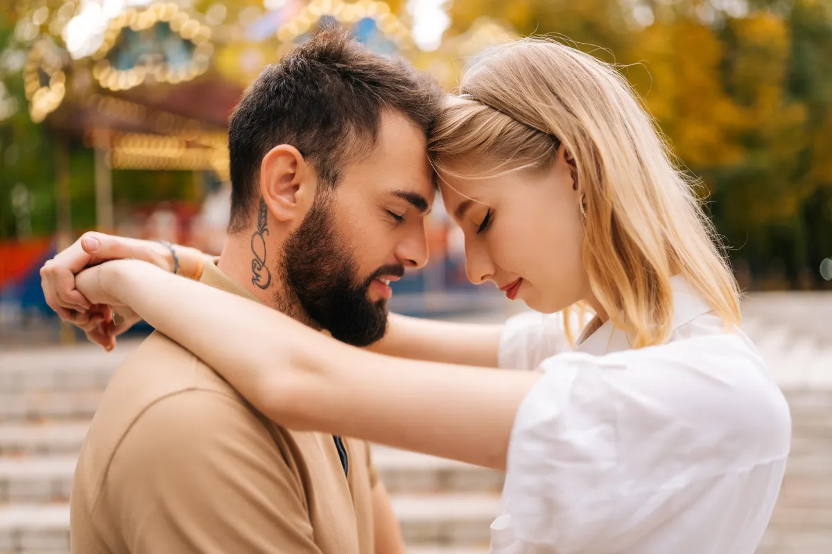 Romantic couple embracing with foreheads touching, celebrating after K-1 spouse visa acceptance for immigration to the USA