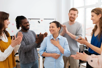 A group of people congratulating a humble woman